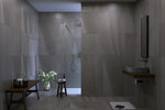 Modern bathroom with gray tiles, a shower, and minimal decor.